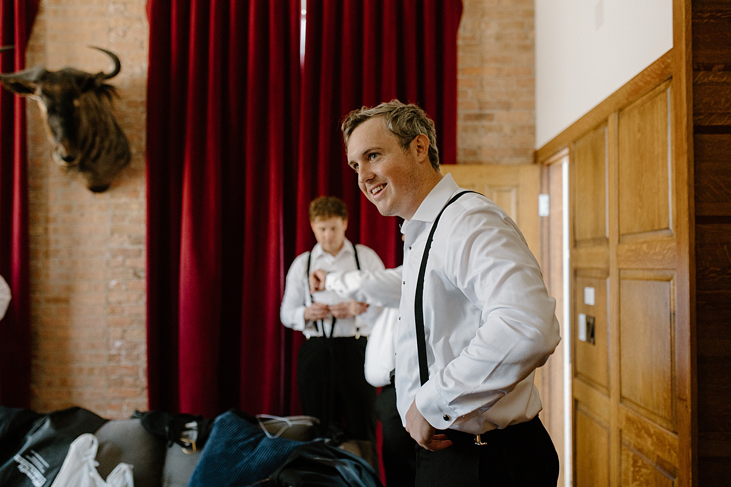 groom gets ready in brick lined wall at Morgan's on Fulton