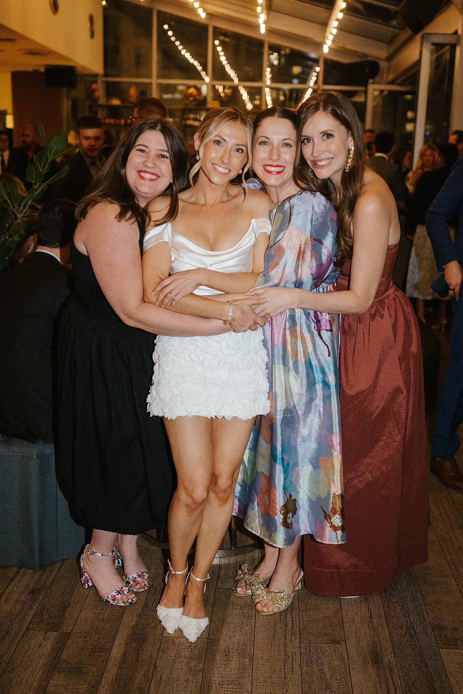 bride surrounded by her friends at reception by Chicago wedding photographer