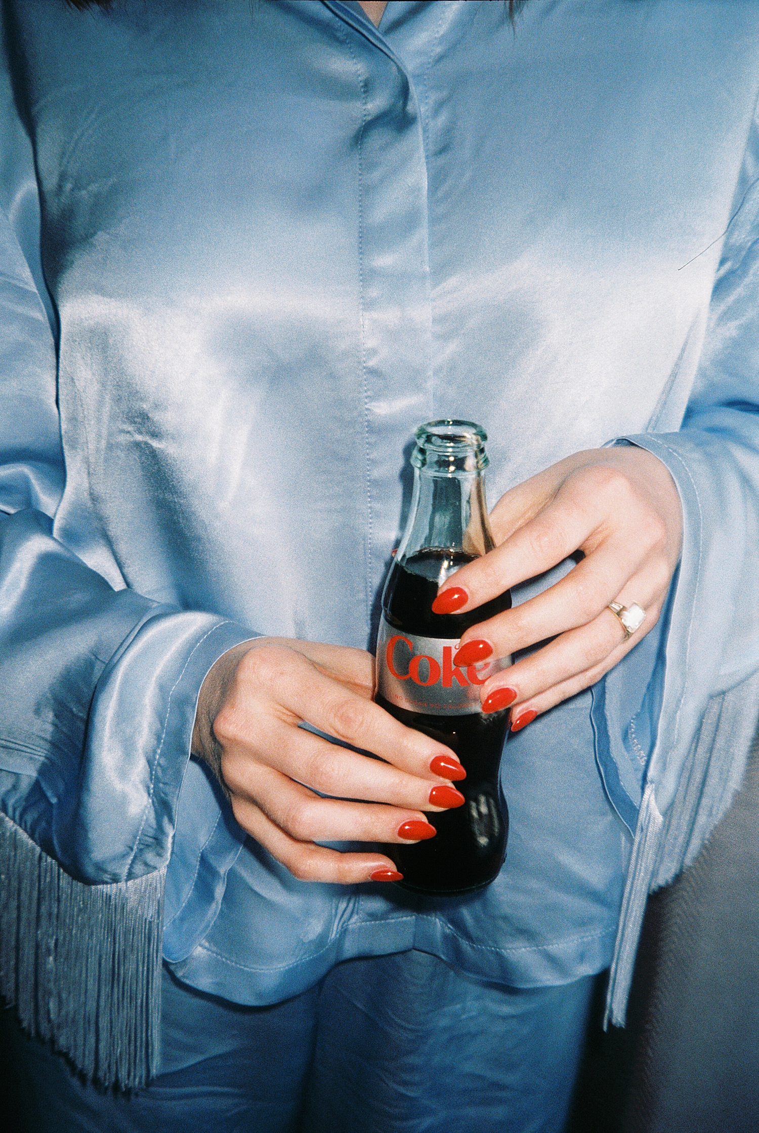 bride holds diet coke in front of her blue silk pjs before portraits at Art Institute of Chicago gardens 