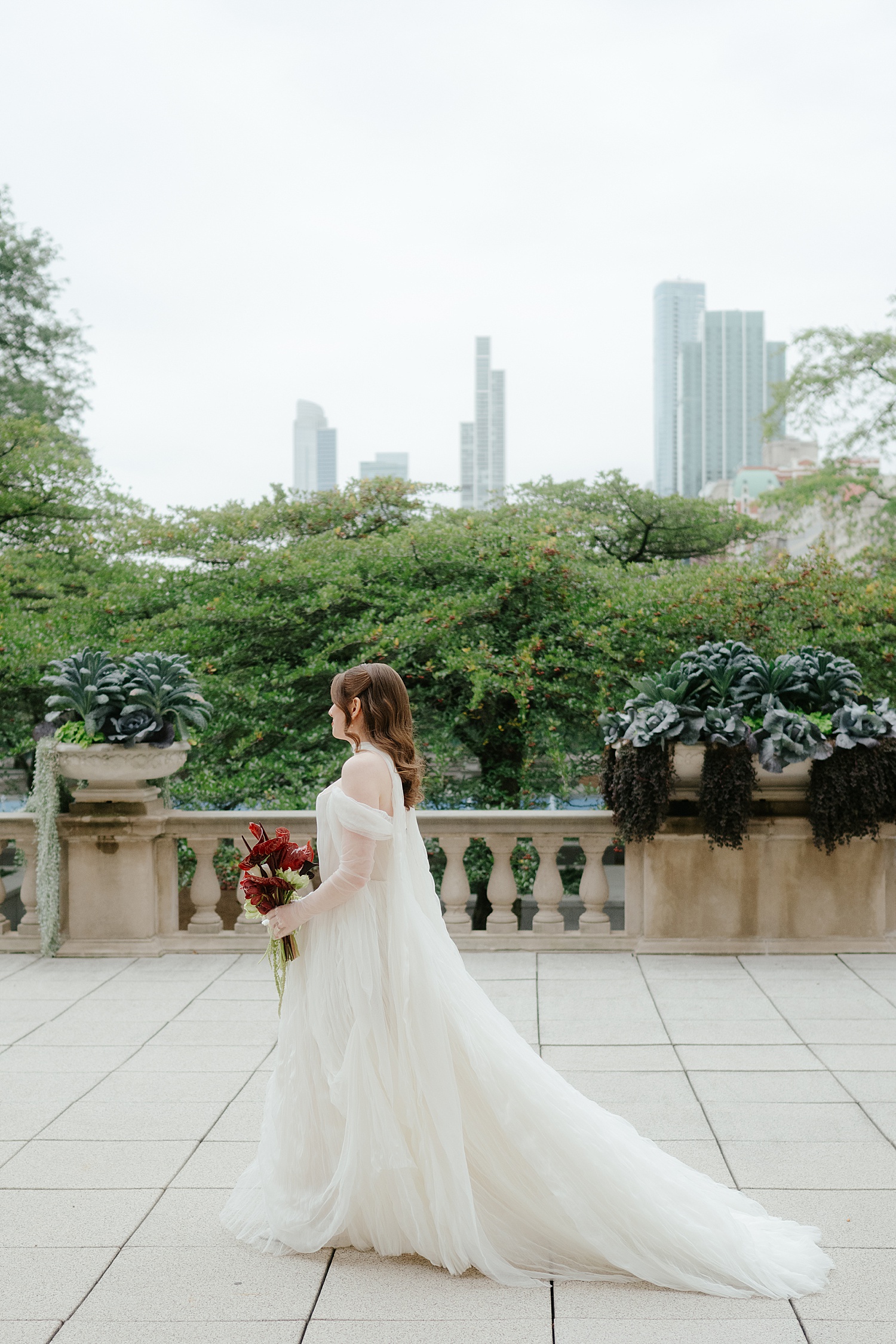 woman in long white dress walks across terrace before reception at Skyline Loft