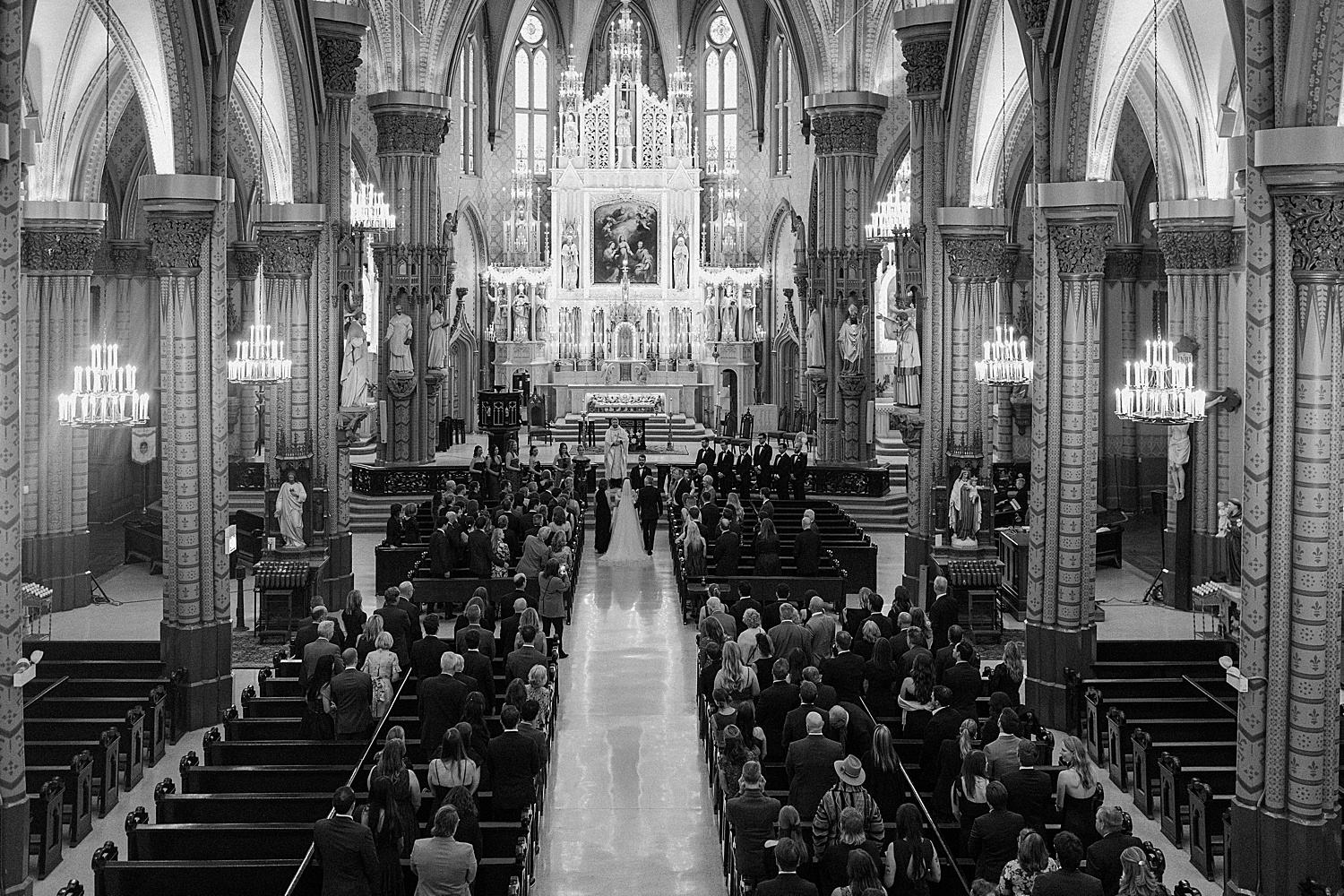 woman walks down long Catholic aisle for her ceremony by Morgan McIntire Photography