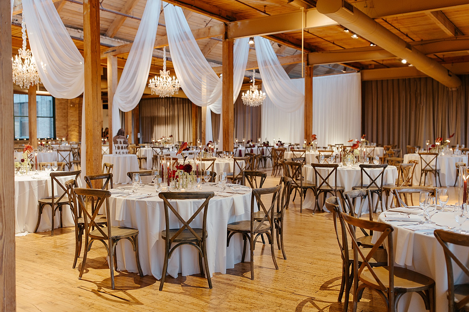 circle tables under draped curtains on wooden floor at Skyline Loft