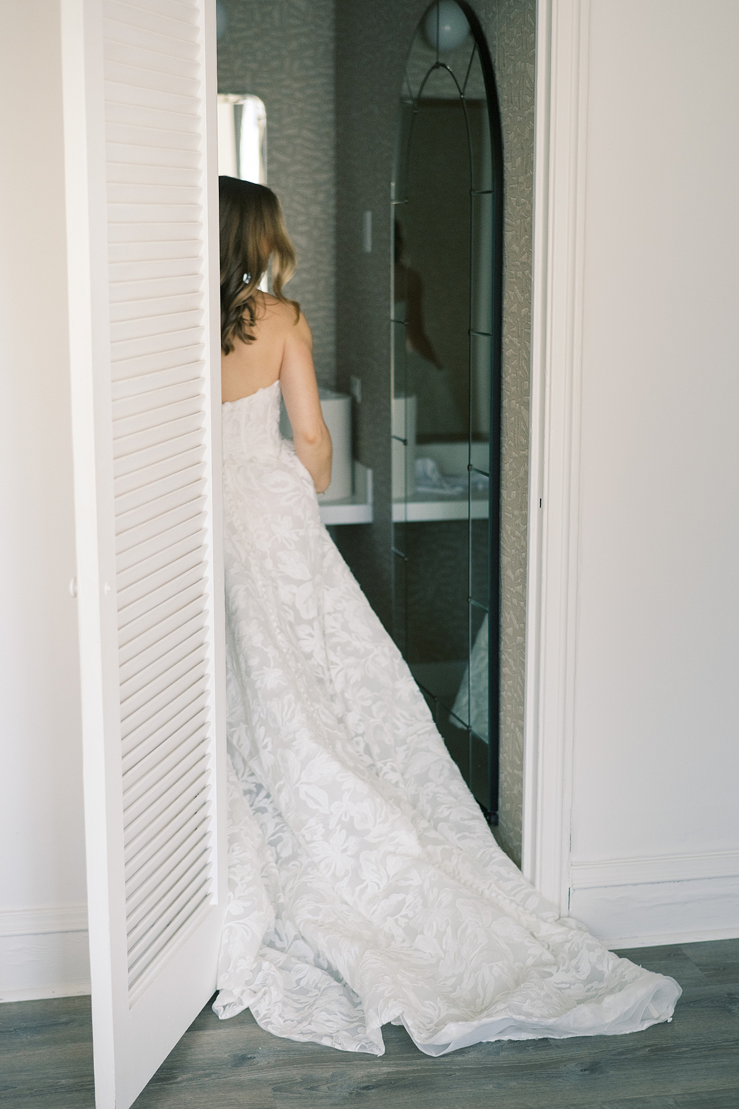 bride looks at herself in the mirror in bathroom for cozy wedding at Theater on the Lake
