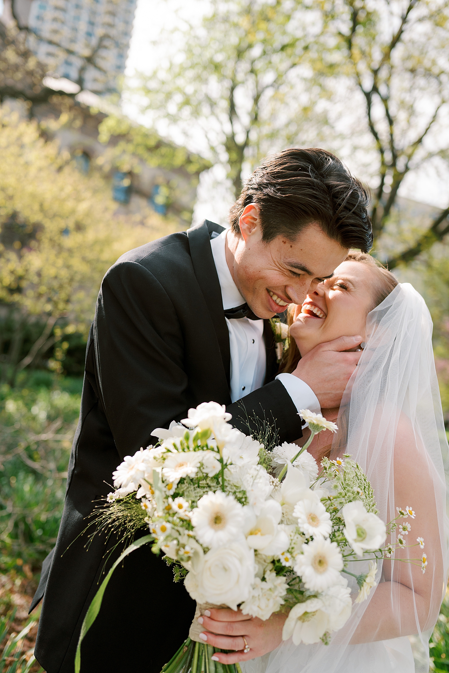 bride and groom giggling together outside for cozy wedding at Theater on the Lake