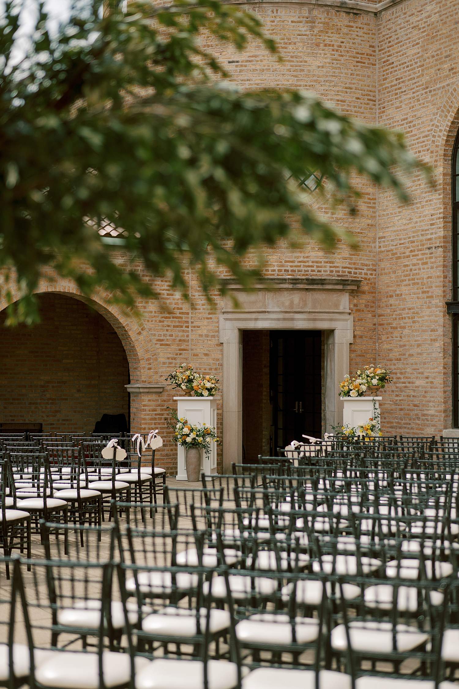 outdoor ceremony space set up with yellow flowers and olive trees by Morgan McIntire Photography