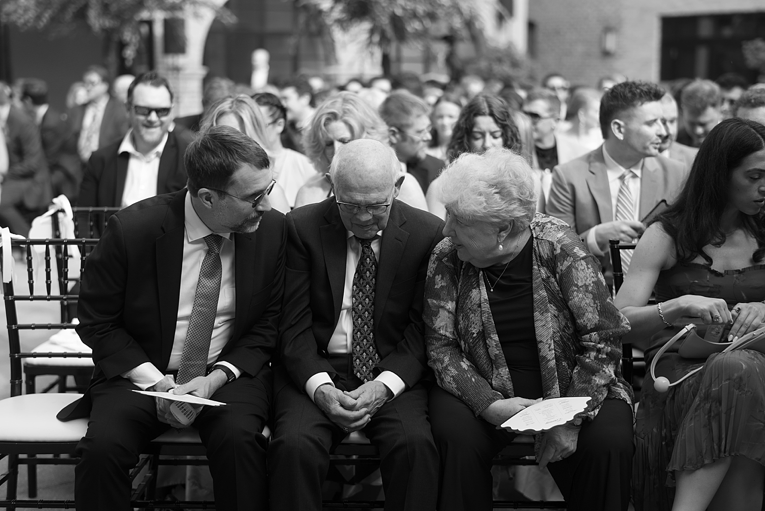 grandparents whisper together in chairs before ceremony by Chicago wedding photographer