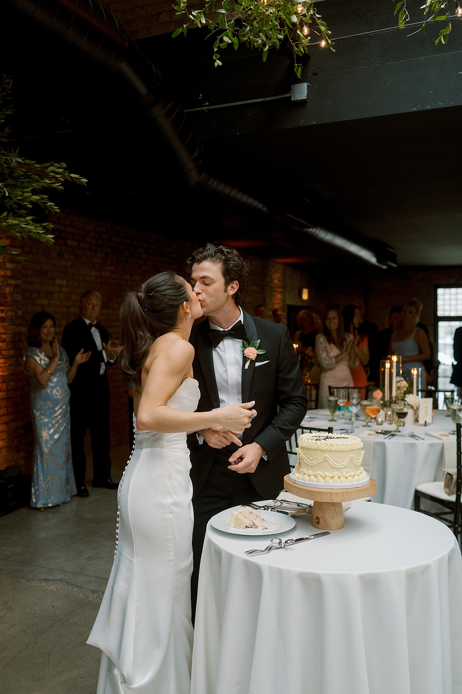 newlyweds kiss before cutting cake for Italian Inspired day